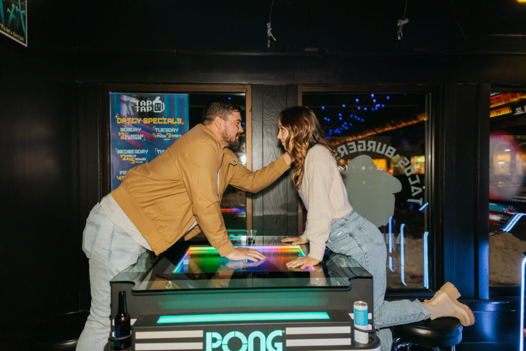 couple kissing and playing pong at arcade bar tap tap in cedar falls
