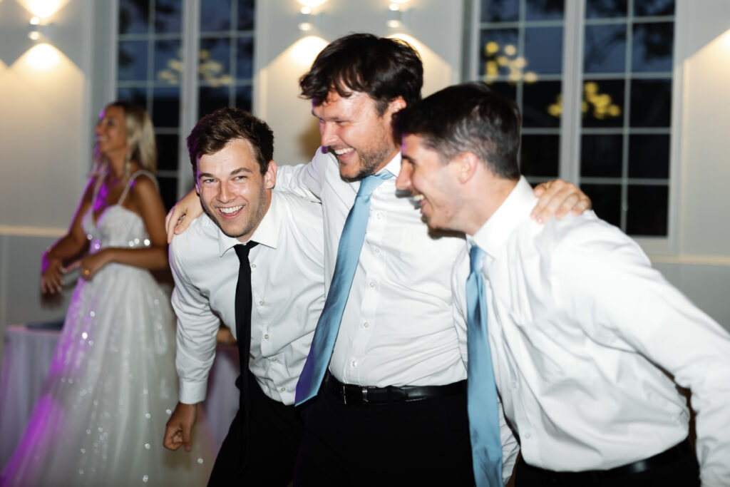 Groom and Groomsmen laughing and dancing at Bella Sala Event Center wedding reception in Tiffin, Iowa, captured by Iowa wedding photographer Alex McCrary.