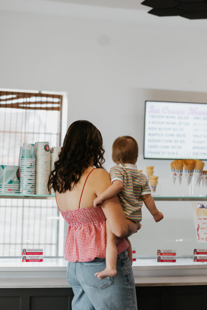 mother and son looking at ice cream flavors in an ice cream shop during a family photo session